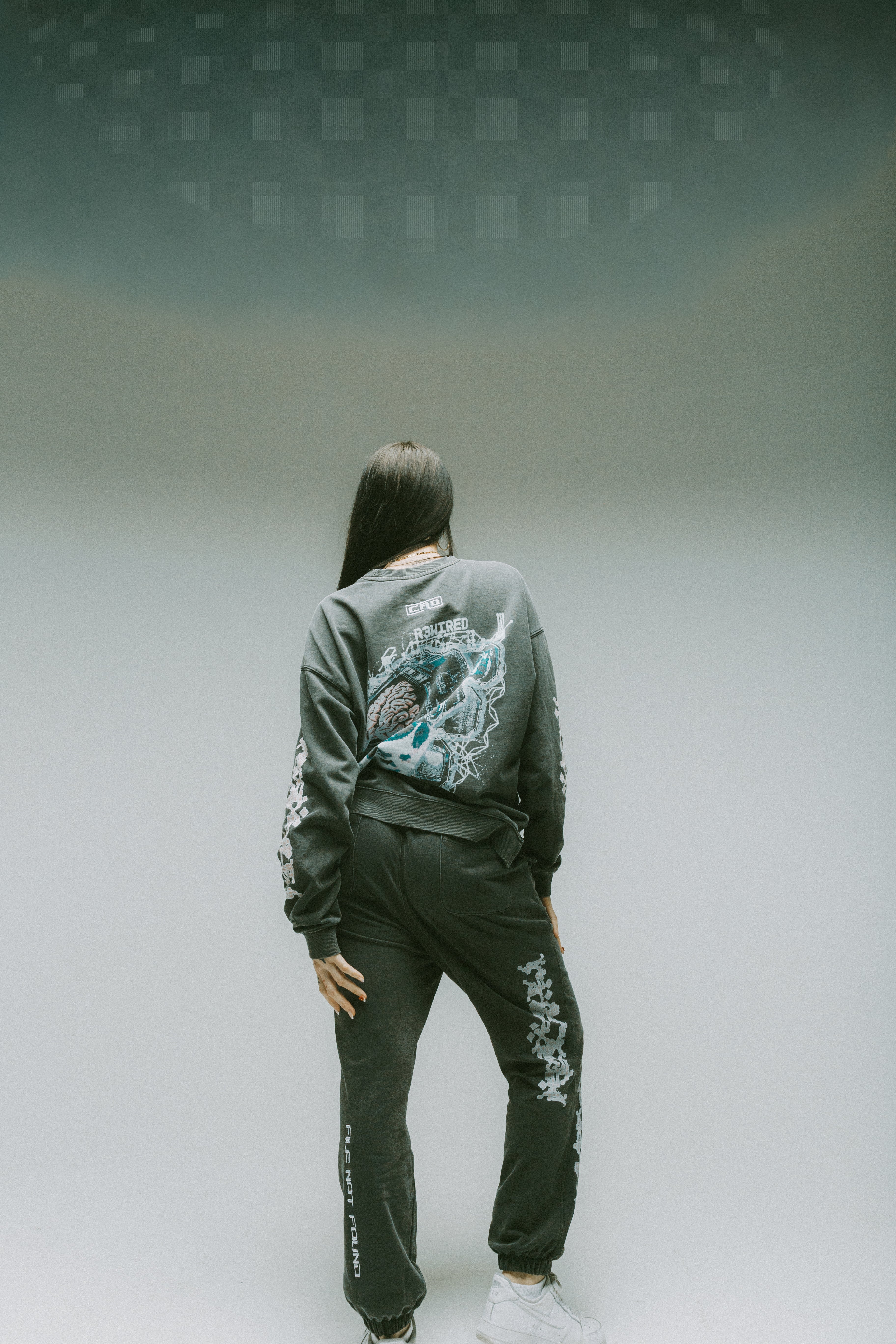 Safe storage Drop Shoulder Sweater Grey worn from the back showcasing embroidery design on the top back.